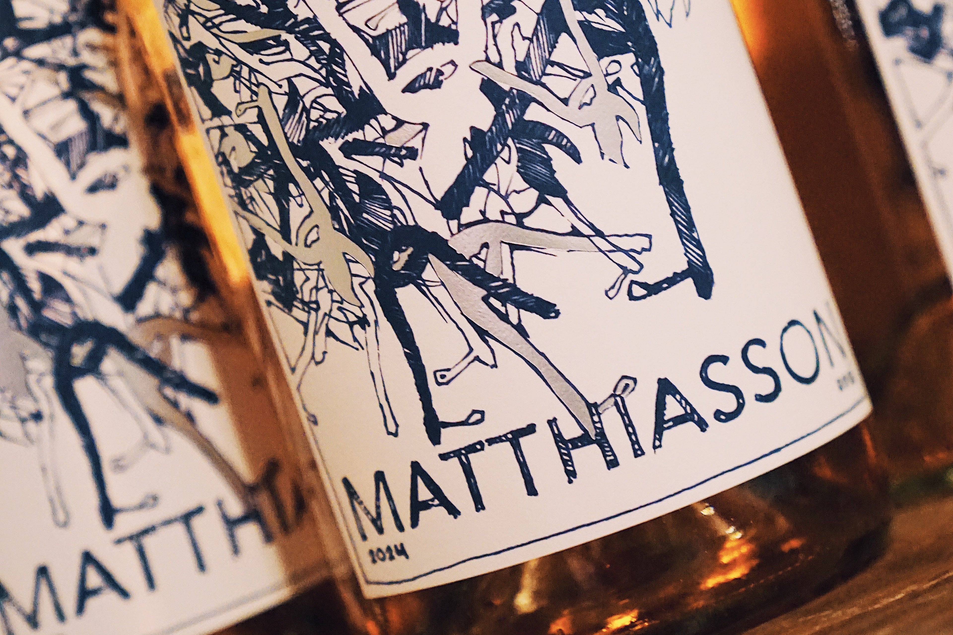 Bottles of Matthiasson rosé wine with decorative labels on a wooden surface