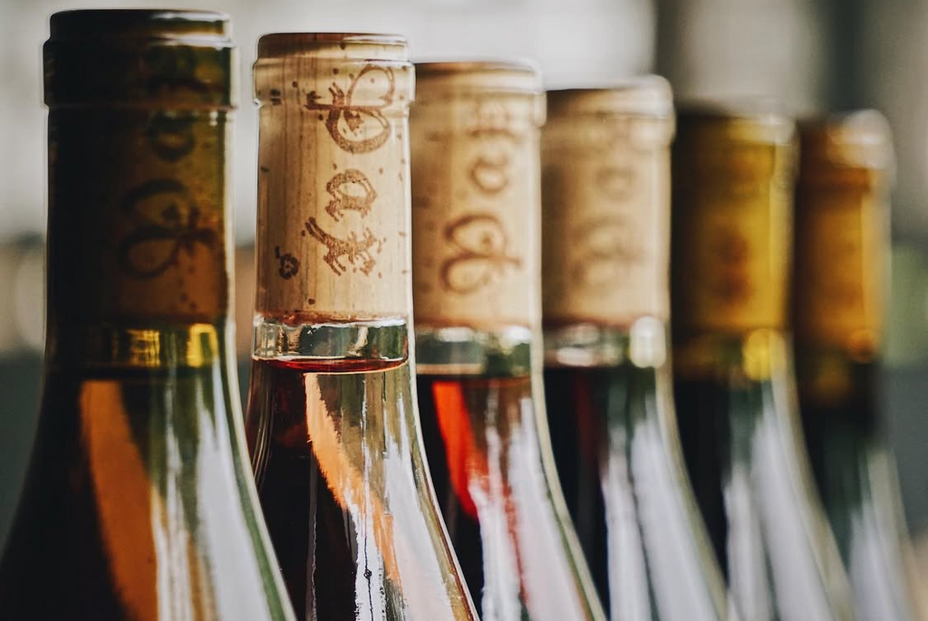 Close-up of the tops of wine bottles with corks in a row, blurred background, Pax Wines