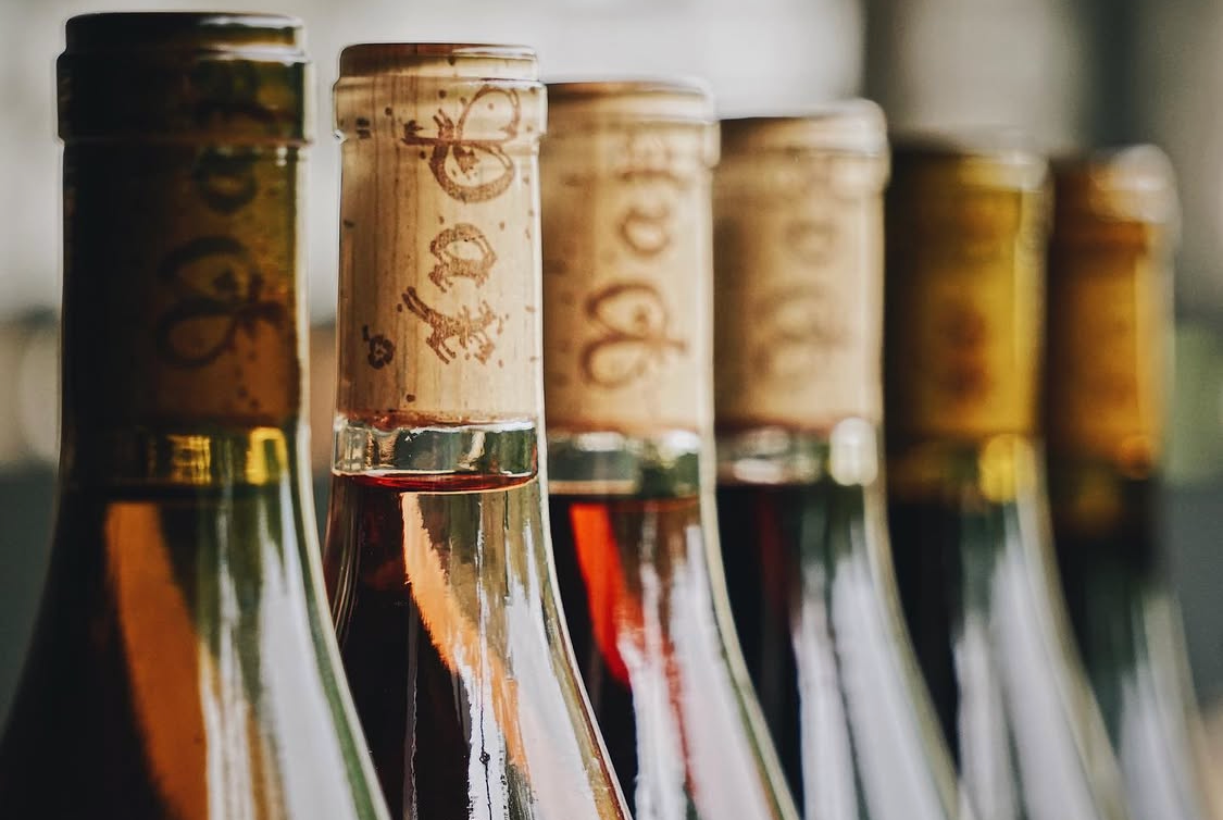 Close-up of the tops of wine bottles with corks in a row, blurred background, Pax Wines