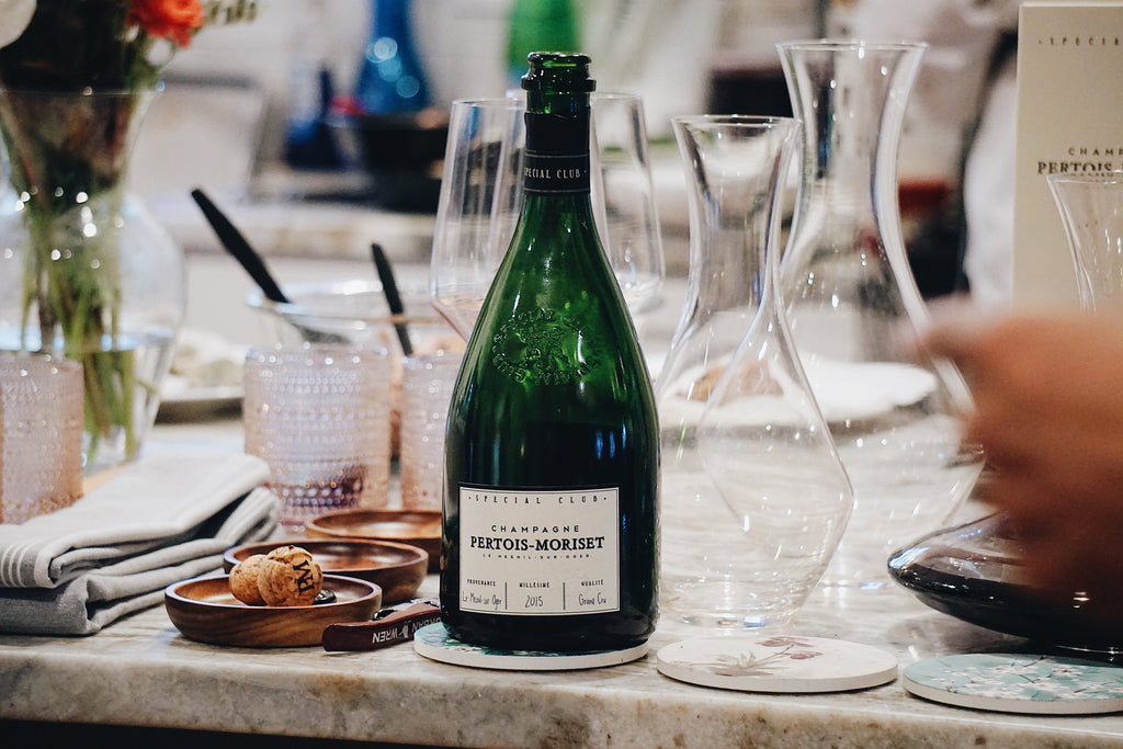Champagne bottle on a table with glasses and decorative items